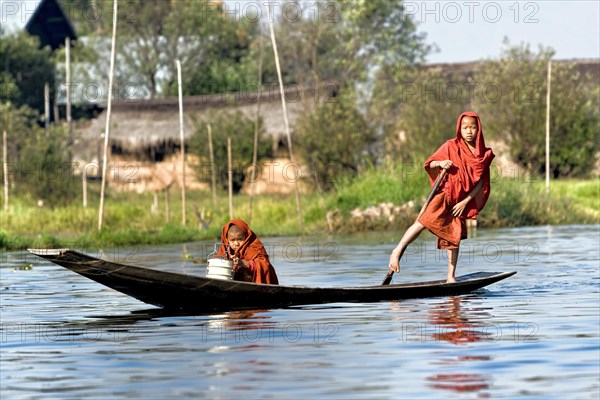 Novices in red robe in boat