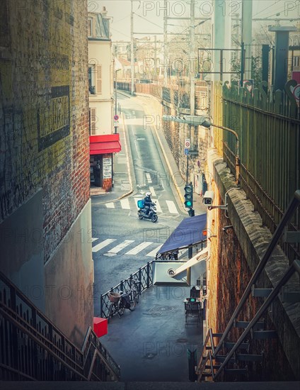 Delivery man or courier driving a motorcycle in the crossroad of city