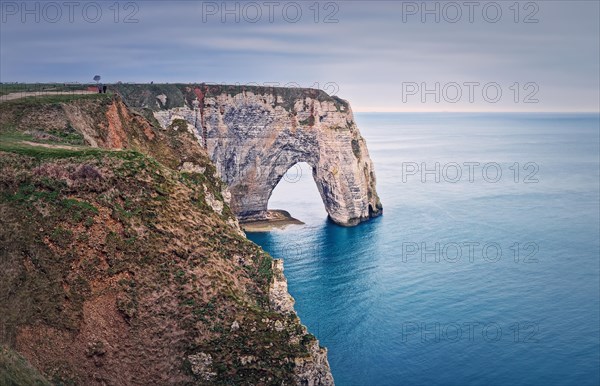 Sightseeing view to the Porte d'Aval natural arch cliff washed by Atlantic ocean waters at Etretat