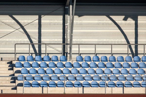 Grandstand with blue seating shells in a sports stadium