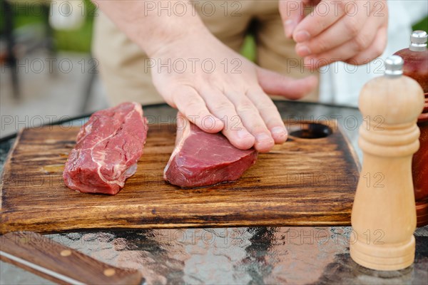 Rubbing olive oil over raw beef strip steak