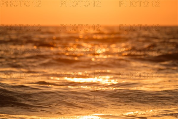 Ocean on sunset backlit with sun defocused blurred background