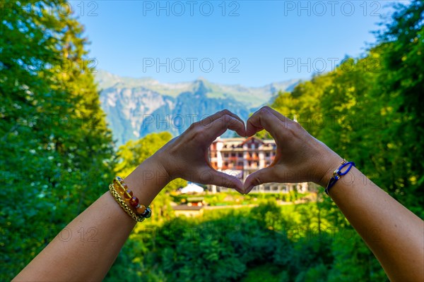 Woman Making a Heart Shape in Front of The Historical Grandhotel Giessbach on the Mountain Side in Brienz