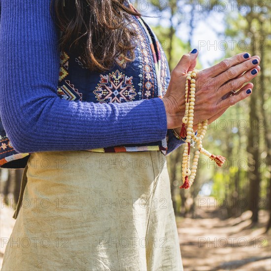 Close up of clasping hands holding a japa mala