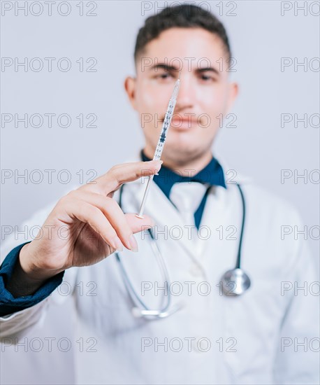 Caucasian doctor holding a syringe on isolated background. Closeup of doctor holding and showing a syringe isolated