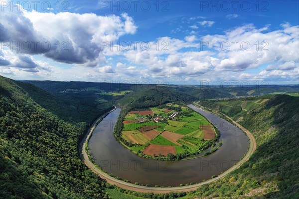 River bend of the Saar. The river winds through the valley and is surrounded by green hills and forests. Serrig