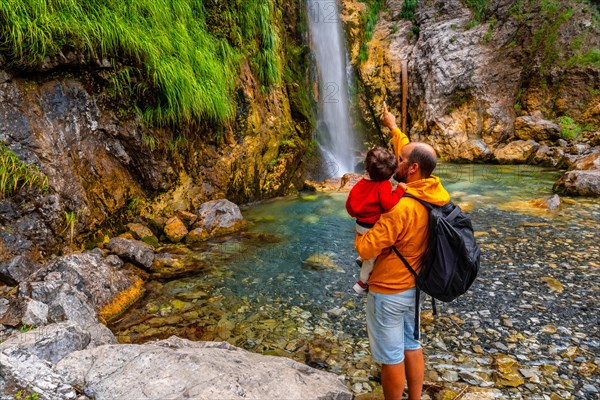 Man with his son at Grunas waterfall in Theth national park