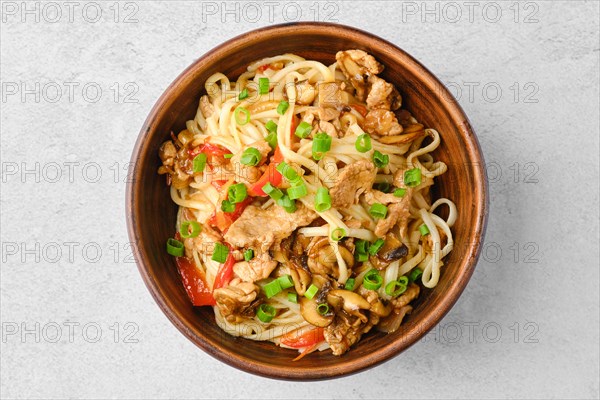 Top view of udon noodle with pork and mushrooms in sweet chilli sauce