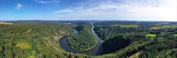 Aerial view of the Saar Loop. The Saar winds through the valley and is surrounded by green forests. Orscholz