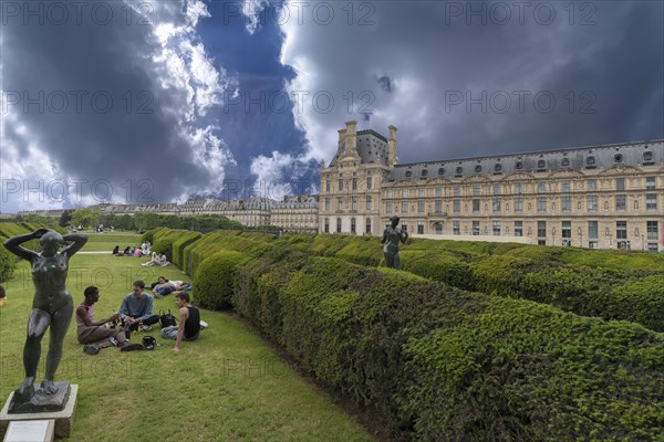 Young people on the green spaces in front of the Louvre