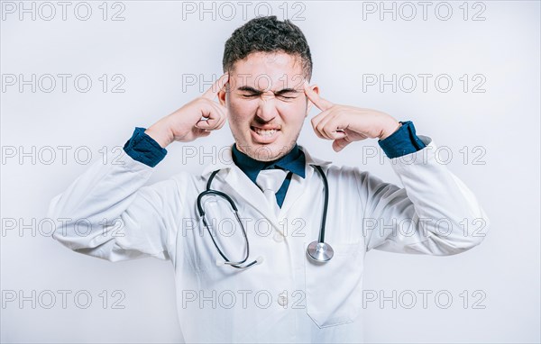 Doctor with migraine holding his head. Fatigued doctor with headache isolated