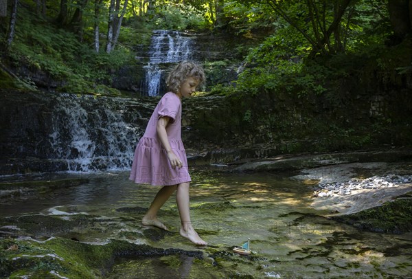 Girl playing on the bank of the Taugl at the Wald Wasser Zauber Weg near Hintersee