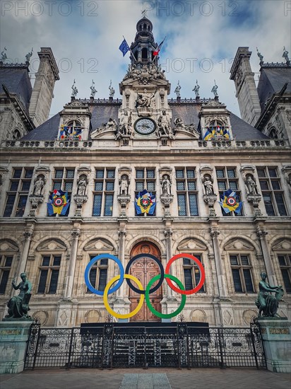 Close up Paris City Hall entrance. Outdoors view to the beautiful ornate facade of the historical building and the olympic games rings symbol in front of the central doors