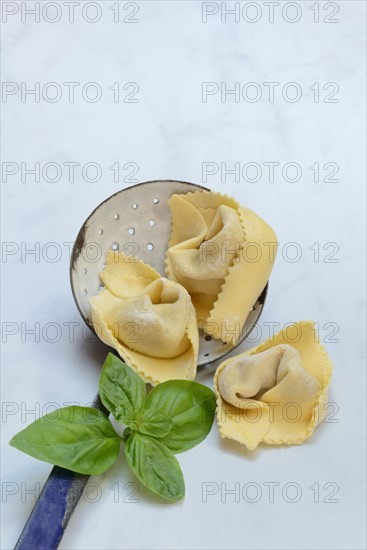 Freshly prepared tortelloni in a sieve ladle