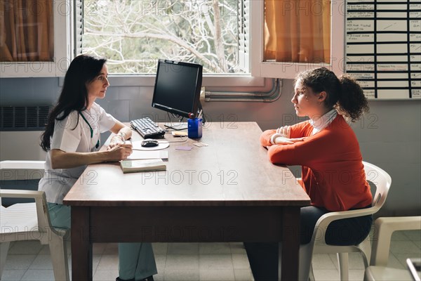 Female physician advising her young patient on contraceptive methods in gynecological consultation