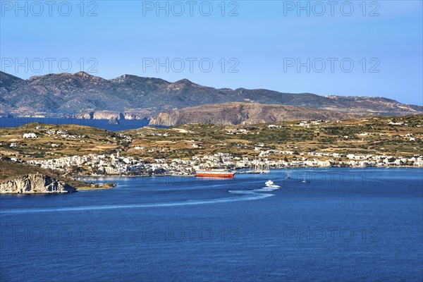 Beautiful summer day and sunshine in typical port town of Greek island. Whitewashed houses by waterfront