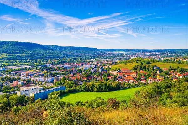 View over the city of Jena from the Galgenberg with the Kernberge in the background under blue sky and veil clouds