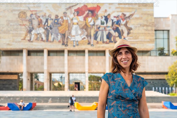 Portrait of a tourist woman at the entrance to the National Historical Museum in Skanderbeg Square in Tirana. Albania