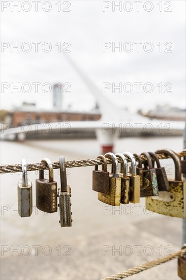 Close-up of padlocks hanging on rails among Puerto Madero channel in Buenos Aires