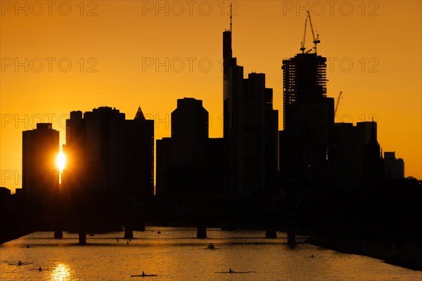 The sun shines through between the skyscrapers of Frankfurt's banking skyline shortly in front of setting