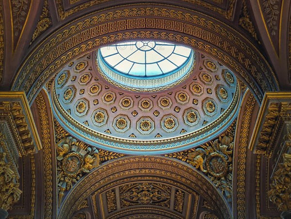 Closeup architectural details of the dome and golden ornate ceiling inside the Versailles palace hall