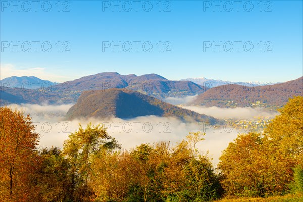 Mountain Range on the Border to Italy on Lake Lugano with Cloudscape and Sunlight on a Clear Sky in Caslano