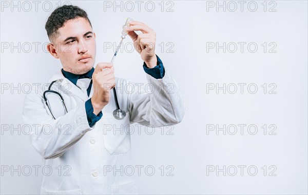 Handsome doctor drawing medicine from a vial with copy space. doctor drawing medicine from a vial. Concept of doctor with disease antidote