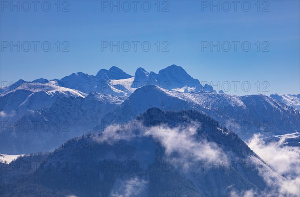 Winter landscape covered in deep snow with a view of the Osterhorn group and the Dachstein massif