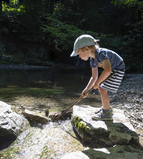 Little boy playing on the bank of the Taugl at the Wald Wasser Zauber Weg near Hintersee