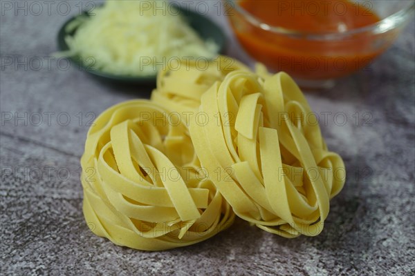 Raw egg tagliatelle pasta with tomato sauce and shredded cheese