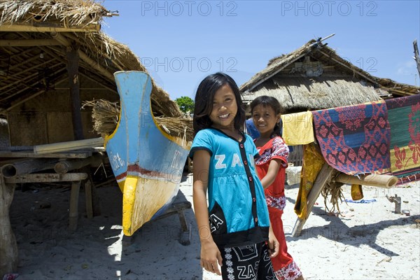 Girl in fishing village between huts and boats