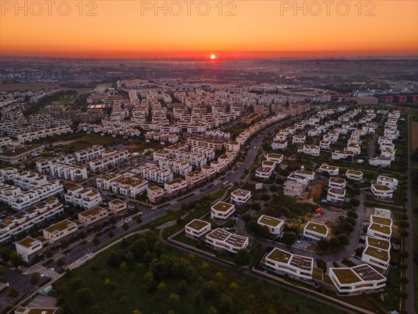 The sun rises behind the Riedberg district of Frankfurt.