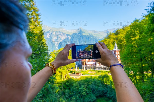 Woman Photographing The Historical Grandhotel Giessbach on the Mountain Side in Brienz