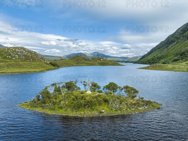 Aerial view of a small island with a Celtic stone cross in the freshwater loch of Loch Stack in the Northern Highlands