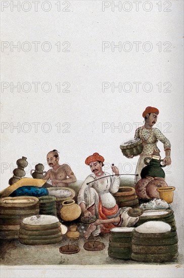 Selling rice at a bazaar. A trader weighs rice at an outdoor market. Rice is the staple food in India and symbolises prosperity