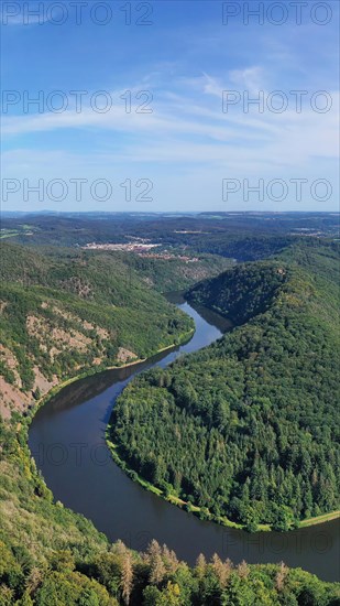 Aerial view of the Saar Loop. The Saar winds through the valley and is surrounded by green forests. Orscholz