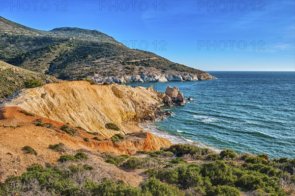 Beautiful sunset view of secluded and remote beach on sunny evening. High yellow cliffs