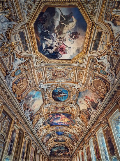 The Galerie d'Apollon a large and iconic room of the Louvre museum. Apollon gallery is a gold decorated hall with zodiac signs ornaments and murals on the walls and ceiling. Architectural masterpiece