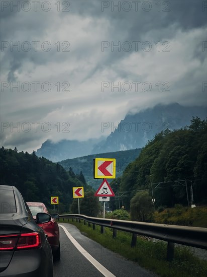 Car moving on a serpentine roadway between the mountains