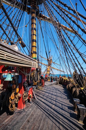 Deck with masts and ropes and bowspirit of wooden Age of sail sailing ship