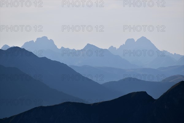Backlit silhouettes of the mountain ridges and peaks of the Dolomites
