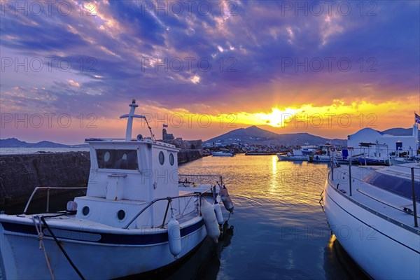 Colorful sunset over quiet Greek fishing village and its harbour