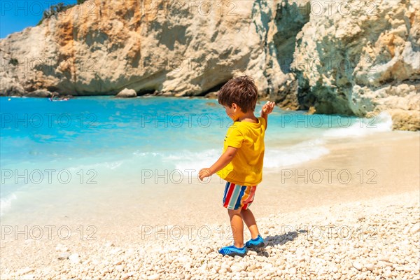 Boy having fun on Porto Katsiki beach in summer vacation Lefkada island