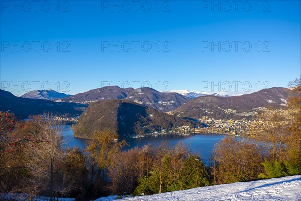 Mountain Range on the Border to Italy on Lake Lugano with Snow and Sunlight on a Clear Sky in Caslano