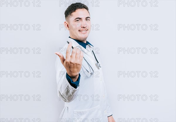 Young friendly doctor inviting to come on white background. Smiling doctor inviting to come isolated