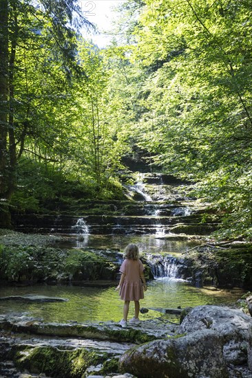 Girl on the bank of the Taugl at the Wald Wasser Zauber Weg near Hintersee