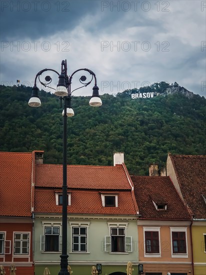 The old town of Brasov with colorful vintage buildings in traditional saxon style with the view to the sign on top of the hill. Popular tourist location in Romania