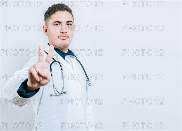 Latin doctor counting number two isolated. Smiling young doctor counting number 2 on isolated background