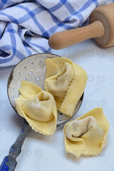 Freshly prepared tortelloni in a sieve ladle