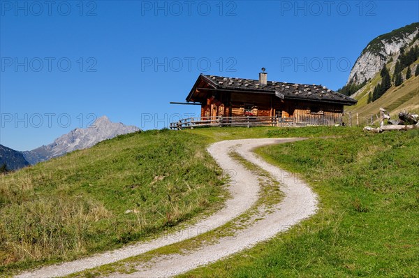 One of the rustic alpine huts on the Kallbrunnalm in the Berchtesgaden Alps with the Loferer Steinberge in the background